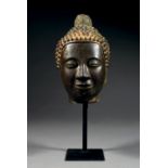 GRANDE TÊTE DE BOUDDHA En bronze de patine sombre comportant des traces de laque et de dorure, les