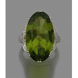 GRANDE BAGUE PERIDOT Elle porte un grand péridot ovale encadré de festons pavés de diamants taille