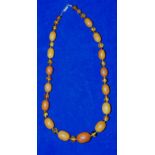 A mottled yellow amber bead necklace re-strung and spaced with small baltic amber beads (Total 50