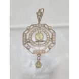 An Edwardian 9ct gold pendant/brooch, set with split seed pearls, drop and central green stone,