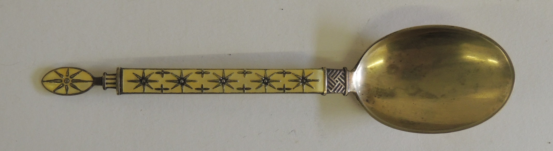 A Norwegian silver and enamelled spoon, by "J.TOSTRUP, NORWAY". The yellow enamelled handle with