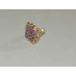 A 14 k gold, ladies dress ring, set with a central panel of nine square cut amethysts, with swag and