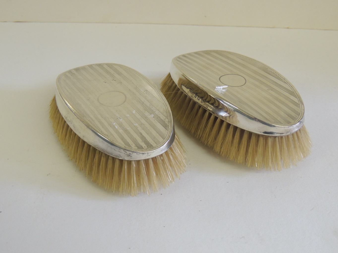 A pair of gents silver backed, engine turned clothes brushes. Hallmarked for Birmingham 1911.