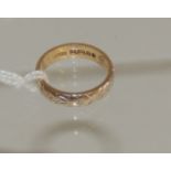 An 18ct gold wedding band with engraved floral decoration. 4.6g approx (size M).