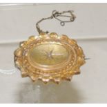 A Victorian hollow, gold metal brooch of oval form, set with a central diamond and with locket back.