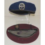 A maroon beret with attached SAS cloth insignia together with a German Bundeswehr blue beret with