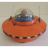 A Japanese battery operated tinplate spaceship, the circular orange vessel with plastic dome
