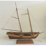 A 20th Century wood model of a two masted sailing vessel on stand, 48cms high