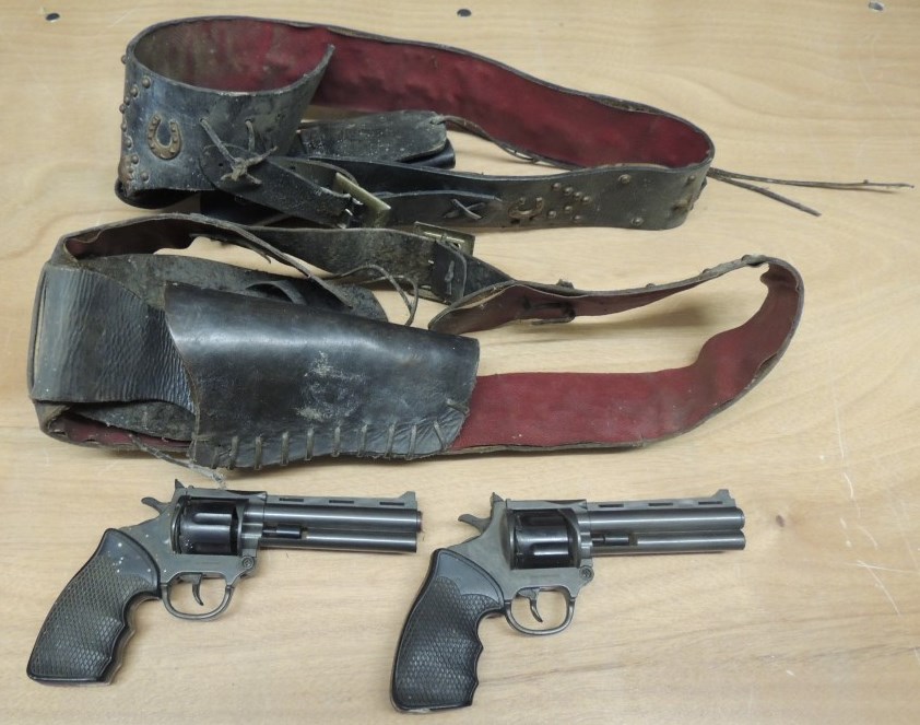 A pair of Larami plastic cowboy cap guns together with two genuine US leather gunbelts and holsters