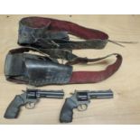 A pair of Larami plastic cowboy cap guns together with two genuine US leather gunbelts and holsters