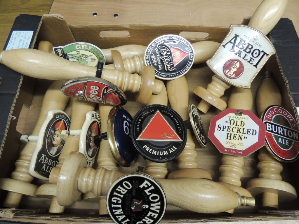 Twelve wood beer pump handles, nine with metal beer clips (2 duplicates) and three with ceramic