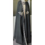 A black cloak with hood, trimmed with gold cord