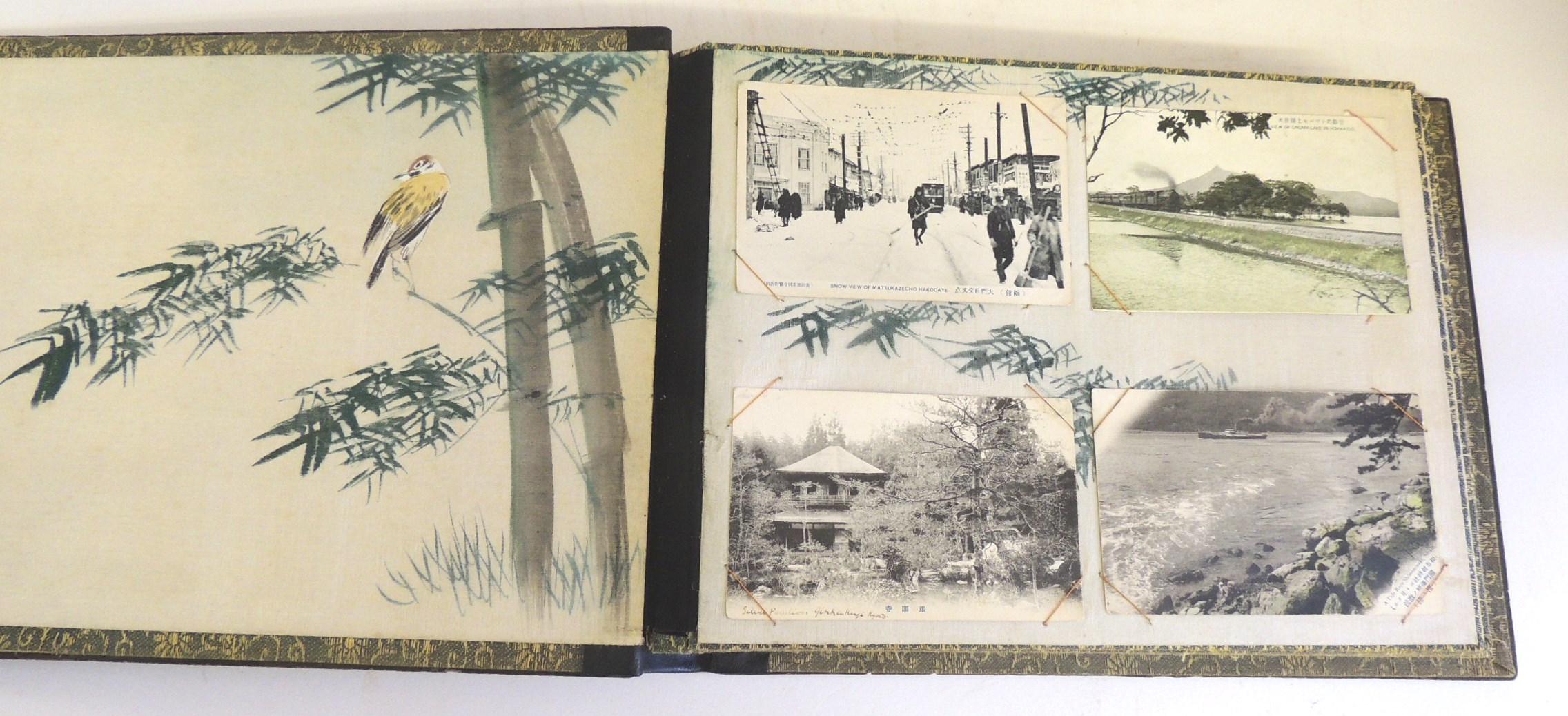 An early 20th Century Japanese album with lacquered covers and containing 36 Japanese postcards