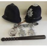 An Avon & Somerset police helmet with white metal badge; an earlier Police hat lacking badge; a wood