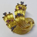 ABSTRACT BROOCH MARKED 750 SET WITH ALTERNATE ROWS OF SAPPHIRES & RUBIES