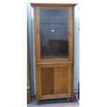 EARLY 20TH CENTURY OAK BOOKCASE WITH GLASS PANEL DOOR OVER PANEL DOOR ON SQUARE SUPPORTS 198CM TALL