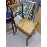 LATE 19TH CENTURY MAHOGANY HAND CHAIR WITH BERGERE PANEL SEAT AND CARVED DECORATION ON SABRE