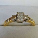 18CT GOLD RING SET WITH 3 PRINCESS CUT DIAMONDS & WITH 3 SIMILAR DIAMONDS TO EACH SHOULDER
