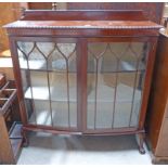 20TH CENTURY MAHOGANY BOW FRONT DISPLAY CASE ON BALL AND CLAW SUPPORTS