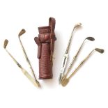 A Silver Handled Manicure Set in the Form of Golf Clubs in a Leather Golf Bag, five sterling