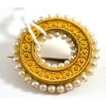 An archaeological revival brooch, of hoop form, two rows of seed pearls around a beaded and rope