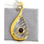 An 18ct gold rock crystal and amethyst pendant, a teardrop carved rock crystal within a yellow