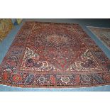 Heriz carpet, Persian Azerbaijan, the terracotta field of scrolling vines around an indigo pole