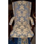 An early 19th century upholstered mahogany wing armchair on turned forelegs and castors