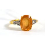 A topaz and diamond ring, the oval mixed cut topaz in a yellow four claw setting, with three eight-