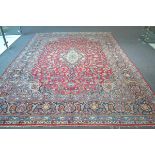 Kashan carpet, Central Persia, the raspberry field of scrolling vines around an indigo and ivory