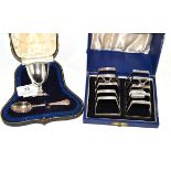 A cased silver Christening cup and spoons together with two silver toast racks