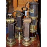 An unusual brass double miners lamp labelled 'Spiralarm J H Naylor Ltd Wigan', 34cm high, two miners