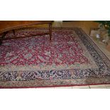 Kirman carpet, South East Persia, the raspberry field of scrolling vines around a floral medallion