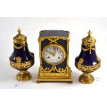 A Sevres style striking mantel clock with garniture, early 20th century, dark blue ground case