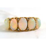 An opal and diamond ring, five graduated oval cabochon opals with pairs of tiny rose cut diamonds in