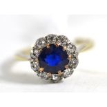 A sapphire and diamond cluster ring, the round cut sapphire in a border of old cut diamonds, in