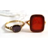 A cornelian intaglio ring, on a forked shoulder shank, finger size O and a foil backed garnet ring