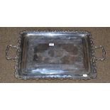 An engraved silver tray with leaf cast border and scrolled handles, 79cm wide