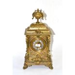 A gilt metal striking mantel clock, circa 1890, urn finial and scroll decoration, 3-3/4-inch dial