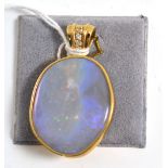 A 9ct gold opal and diamond pendant, the unevenly shaped polished opal within a yellow collet frame,