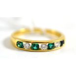 An 18ct gold emerald and diamond ring, alternating round brilliant cut diamonds and emeralds in a