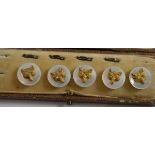 Five mother-of-pearl and 9ct gold dress studs decorated with fox head masks, in a fitted case