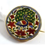 An Islamic? brooch, the round form enamelled in blue, red, white and green to depict a stylised
