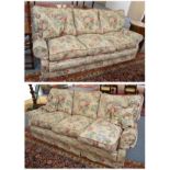 # A pair of feather-filled three seater sofas with floral covers