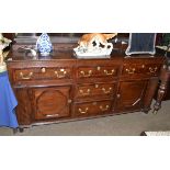 George III oak and mahogany cross banded dresser base with five drawers and two cupboard doors
