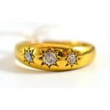 An 18ct gold three stone diamond set gypsy ring