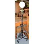 A brass and wrought iron adjustable oil lamp