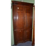 A late George III oak free standing corner cupboard