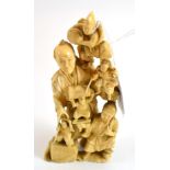 A Japanese one piece ivory carving/okimono of a group of figures, circa 1900 (re-glued)