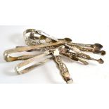 Ten pairs of silver sugar tongs, many repaired